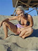 Blonde at the beach pulling her bikini bottoms over flashing her pussy