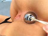 Stainless steel ben-wa-balls being slowly pulled out of her anus.