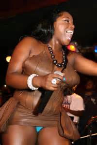 Foxy Brown in brown leather dress