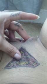 Superman logo tattooed above hairy pussy.