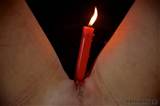 Burning candle is dripping hot wax all over the pussy